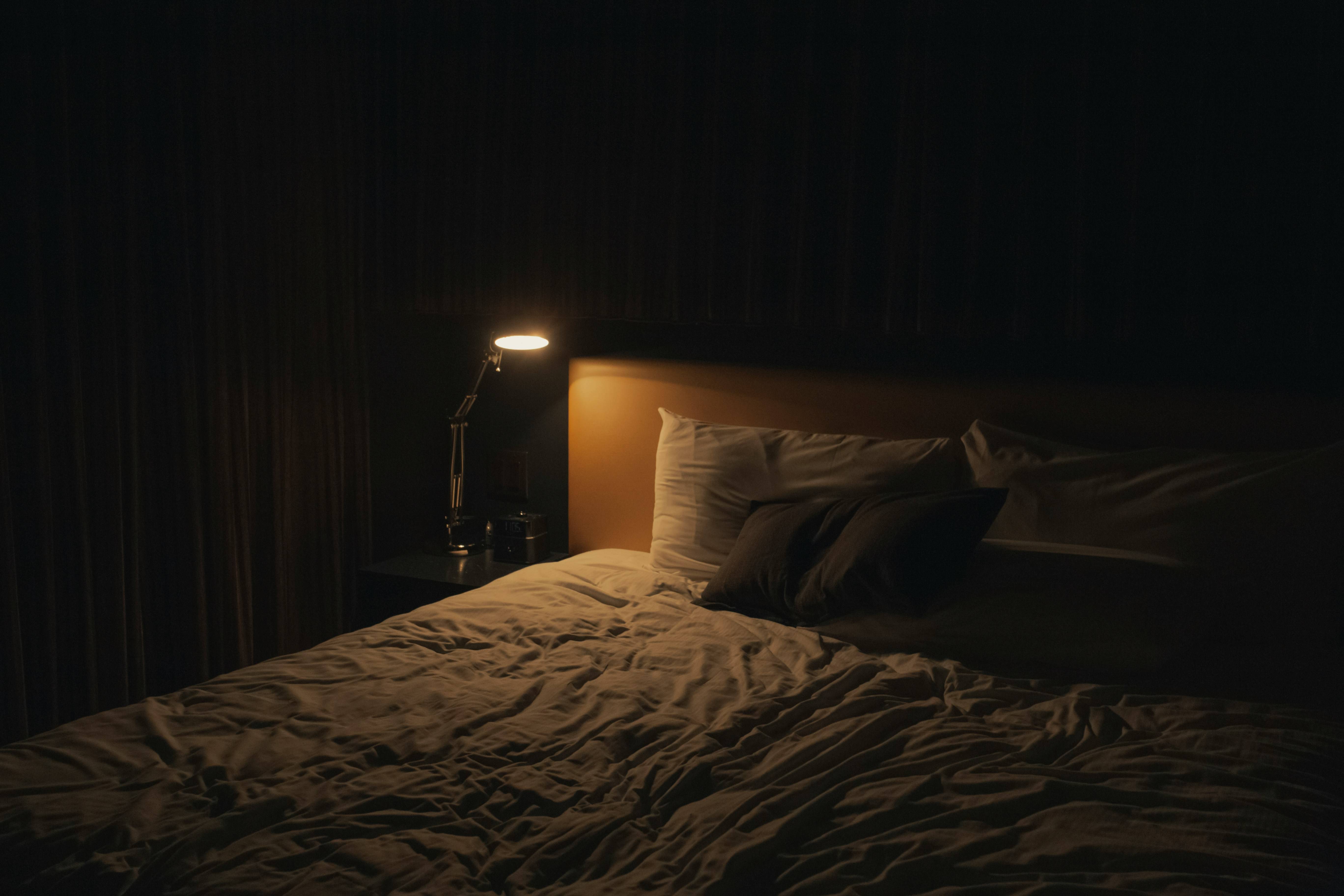 Dim lighting is cast onto a bed.