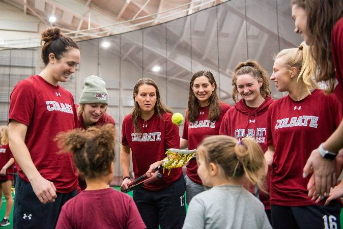 Women's Lacrosse team with local school children