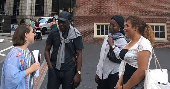 Sophie Louallier ’18 speaks with a group of people on a city sidewalk