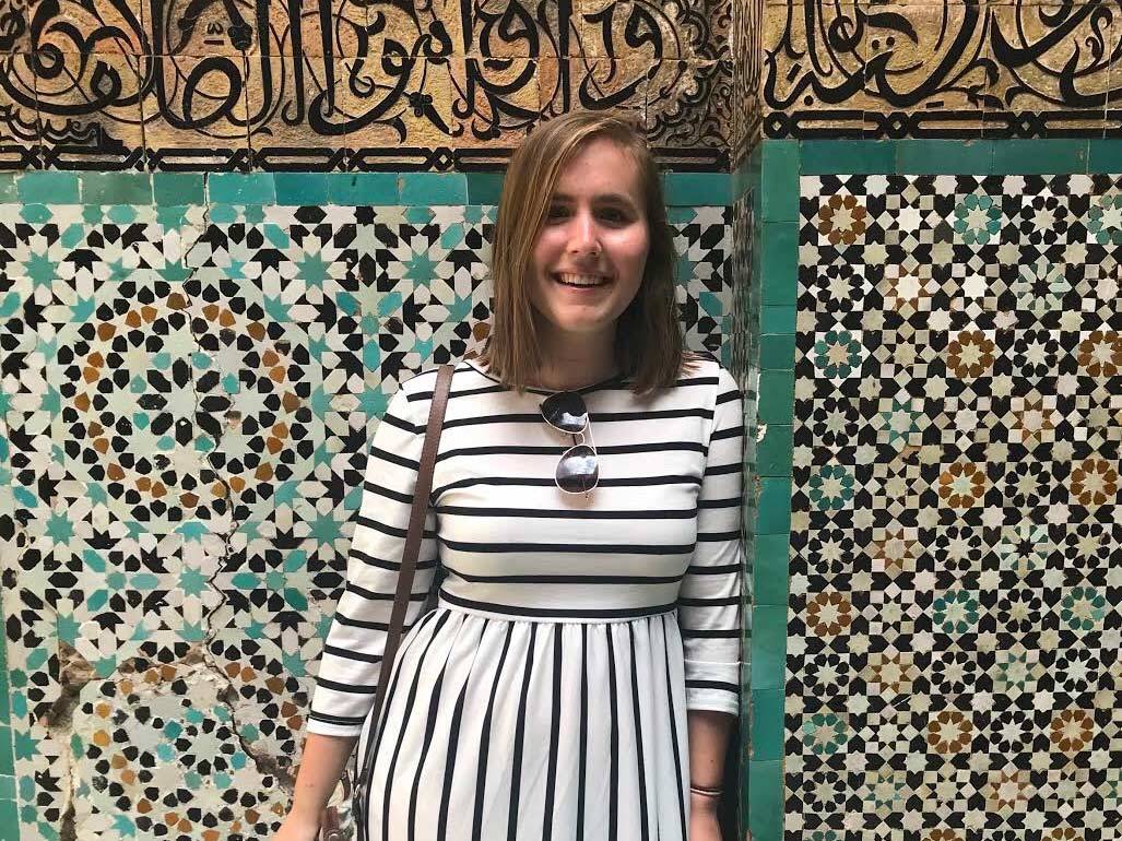 Melissa Verbeek leans against a tiled wall abroad