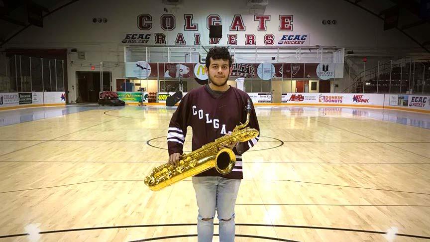 Ryan Rios ’20 with his baritone saxophone in a campus gymnasium