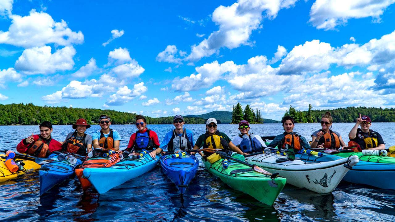 Ten students on kayaks in a river