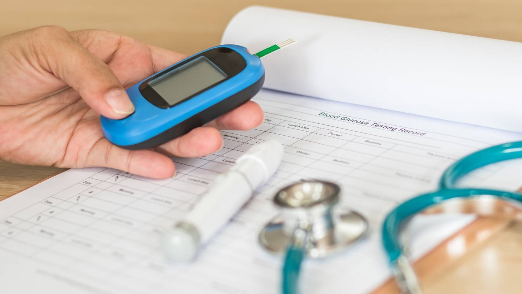 Photo of thermometer, stethoscope, medical chart and sugar testing meter.