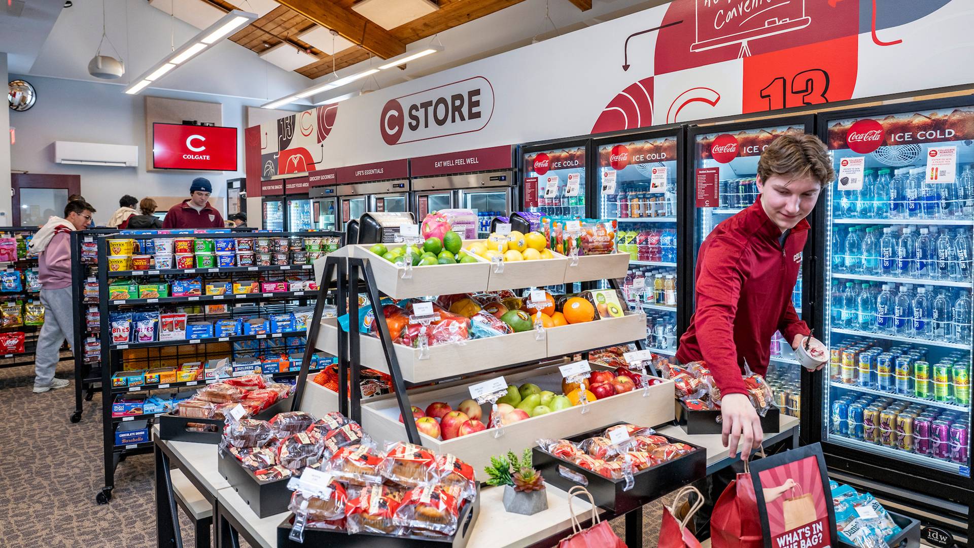 Student reaches for giveaway bag by C Store produce section