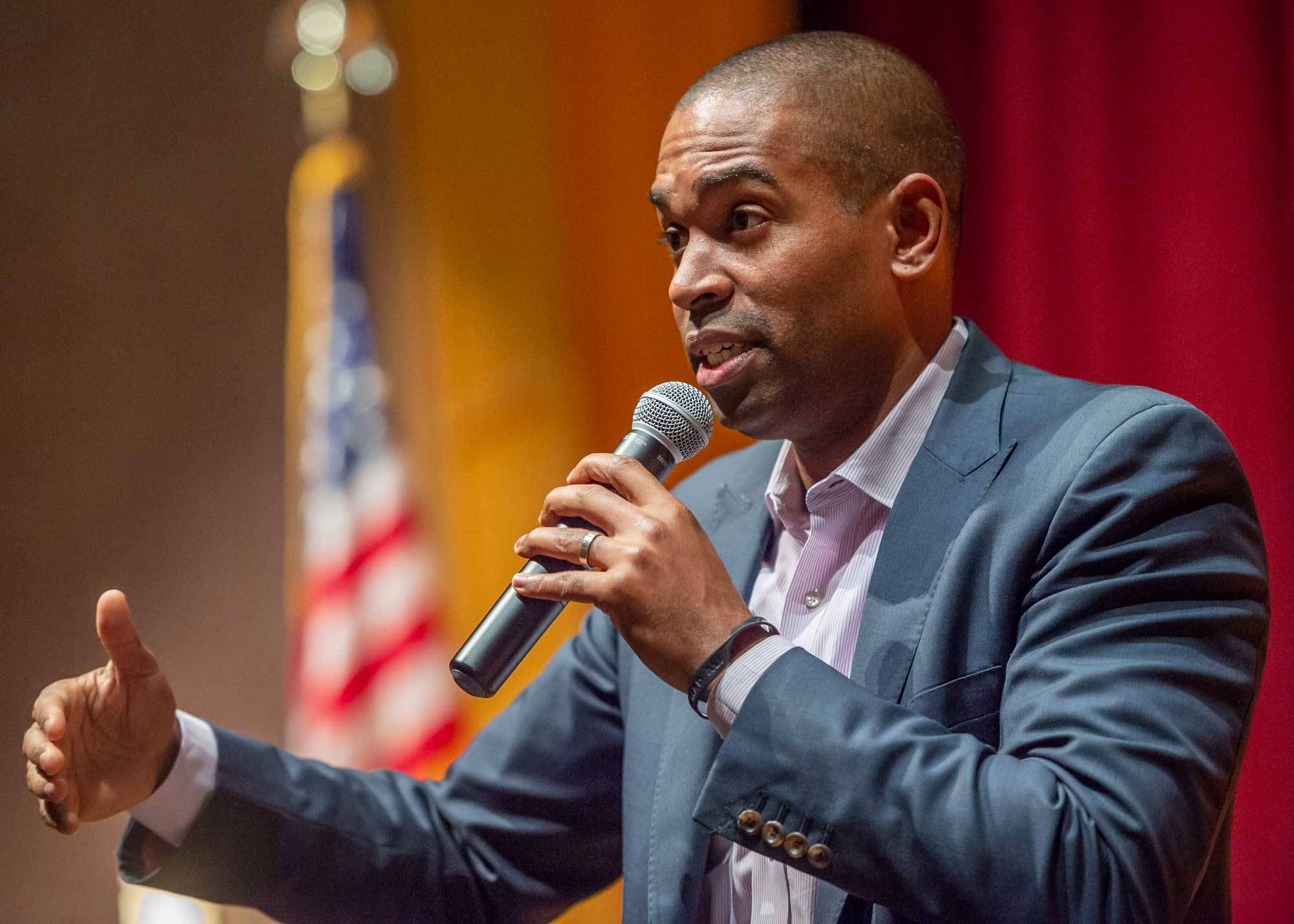 Antonio Delgado delivers a speech with American flag in the background