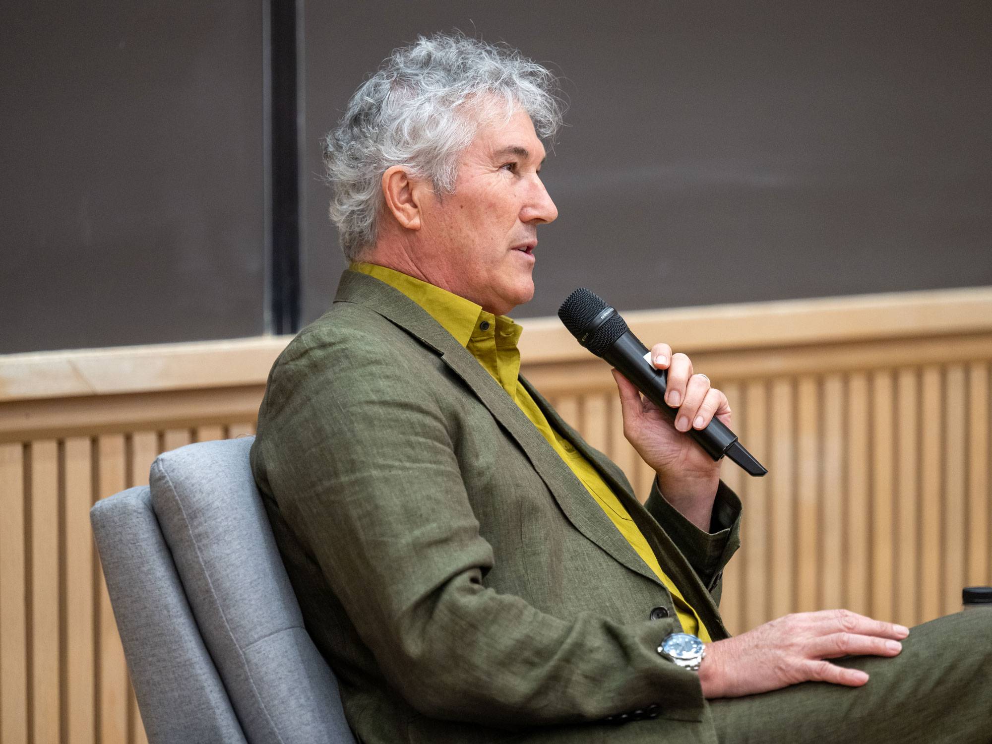 John Tomasi speaking into microphone