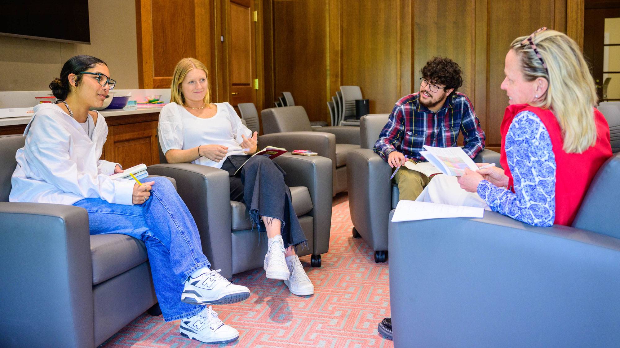 Three students speak at staff member