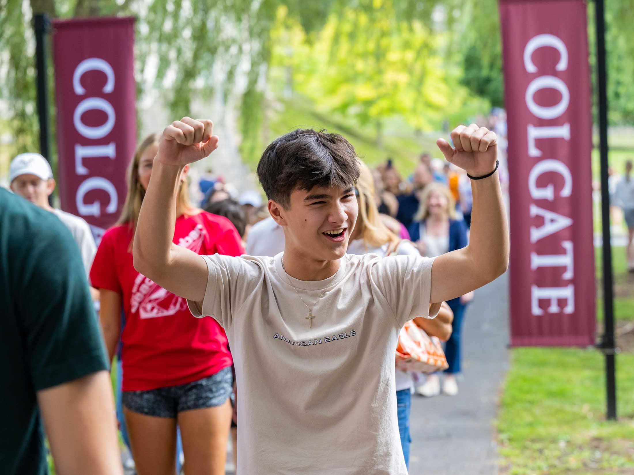 Student cheers as he walks between Colgate banners