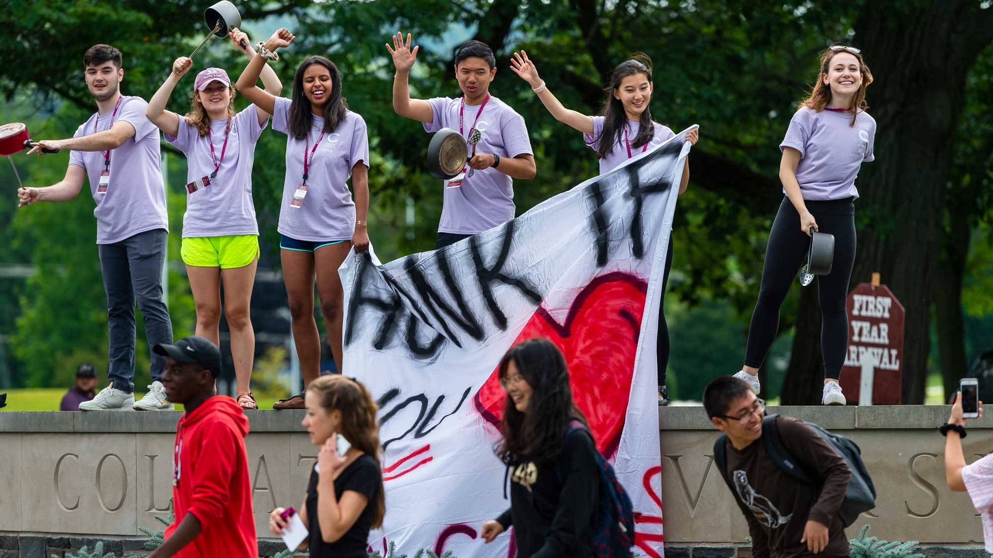 Students hold sign reading "Honk if you love Colgate"