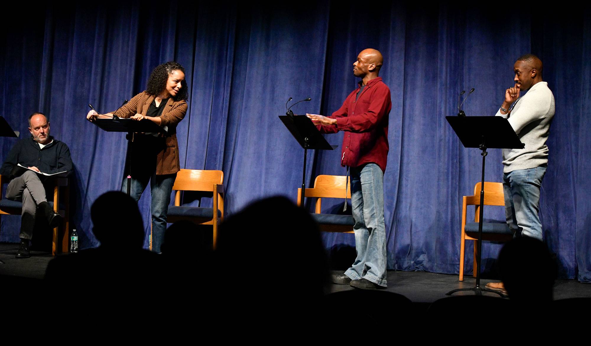 actors stand on stage in front of podiums