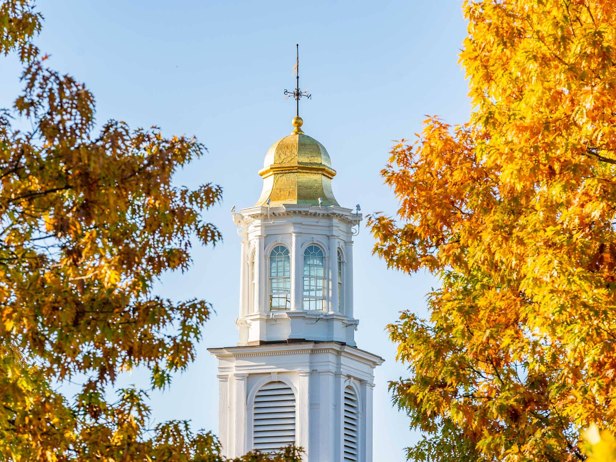 Chapel spire flanked by fall foliage