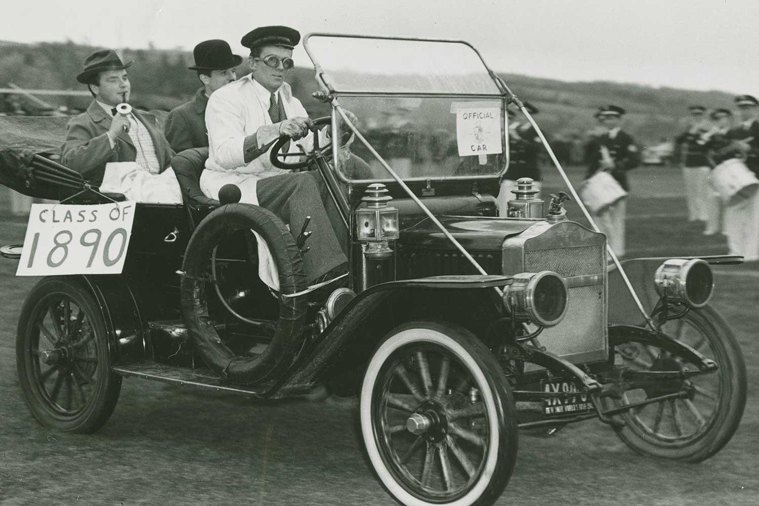 Students from the Class of 1943 driving an antique automobile