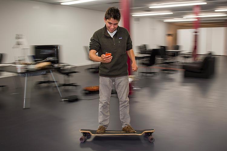Harry Raymond, founder of an on-line app to explore beers, wines and spirits, skateboards through the Colgate University Thought Into Action Incubator, located on Utica Street in downtown Hamilton, NY.