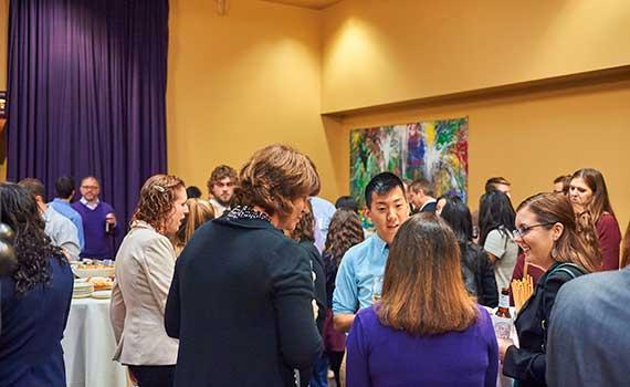 Students and alumni stand together at networking event