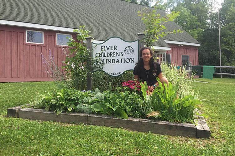 Gaby Bianchi ’19 sits among flowers at the Fiver Children's Foundation
