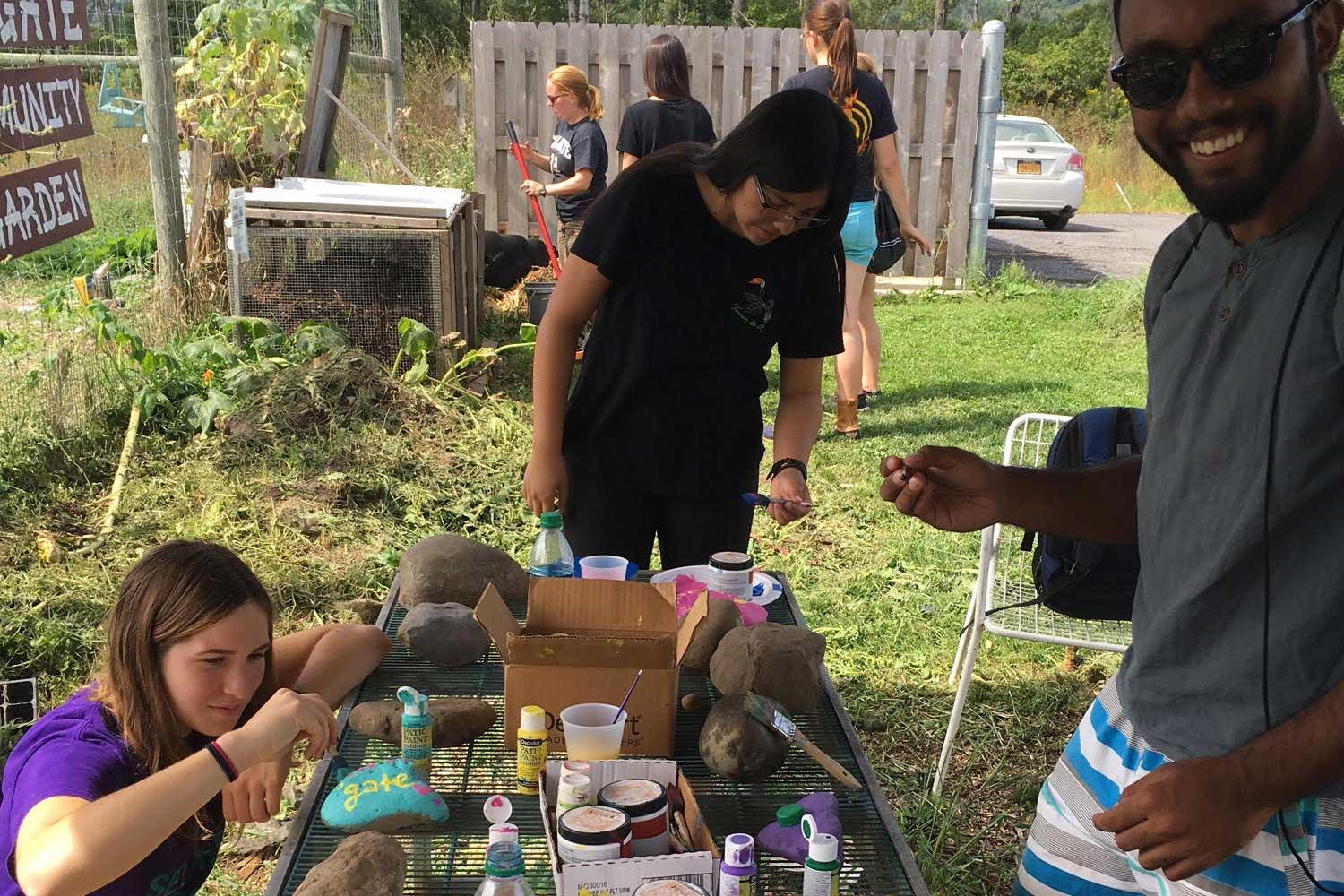 Students gathered around a table outside the Colgate Community Garden