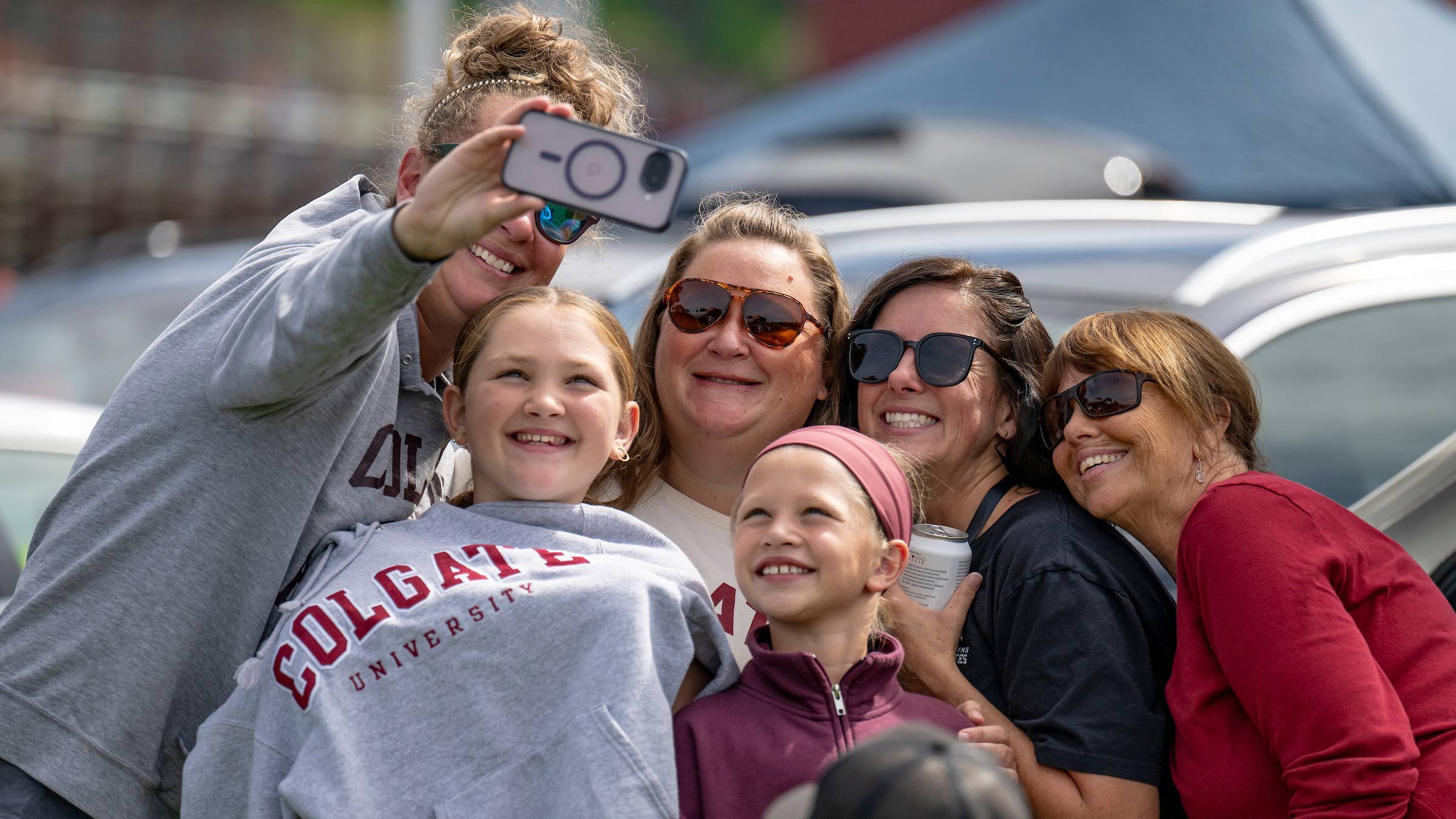A family wearing Colgate sweatshirts pose for a selfie during Family Weekend 2026