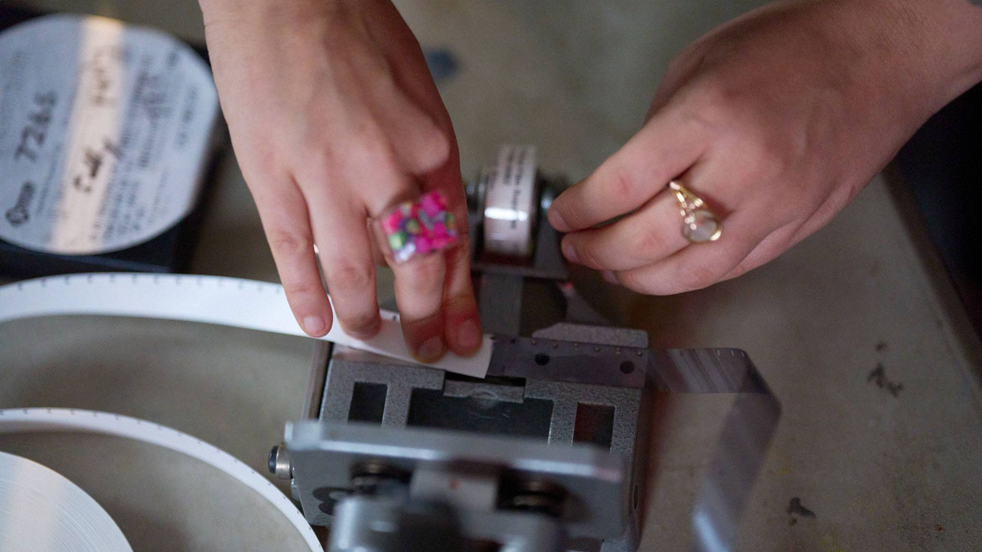 Hands loading film into movie camera