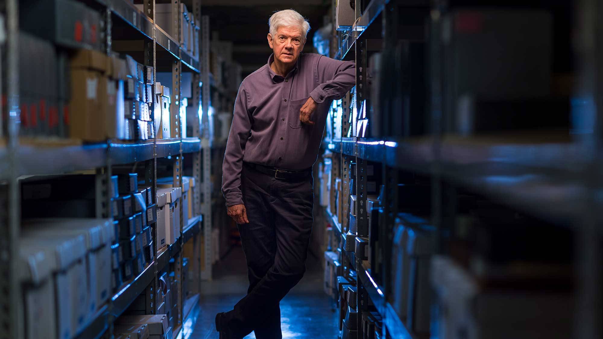 James Allen Smith stands among archive stacks