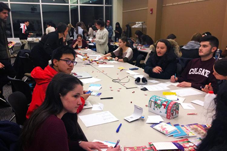 Students in a conference room writing thank you notes