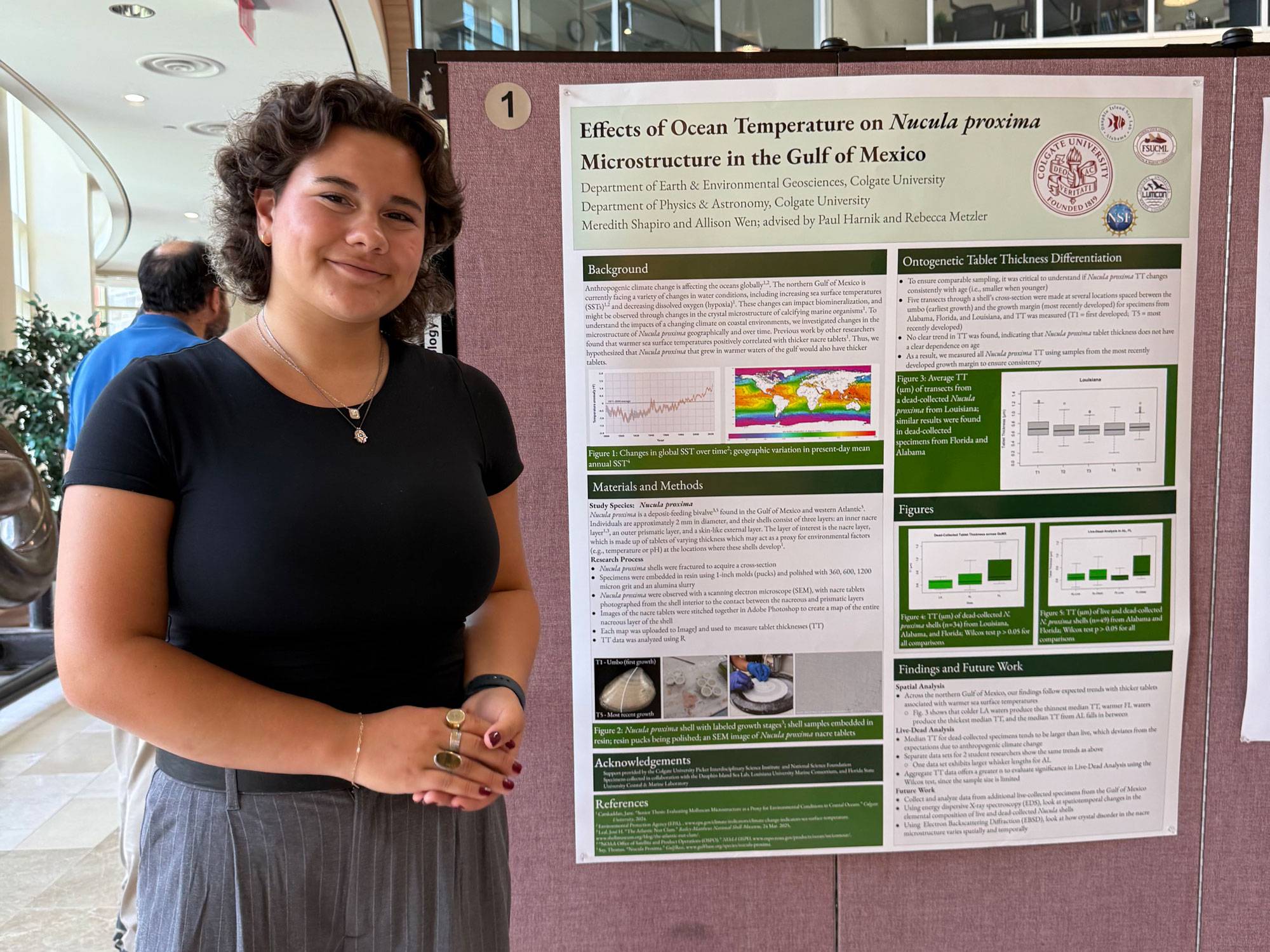 Meredith Shapiro ’28 standing beside her presentation poster
