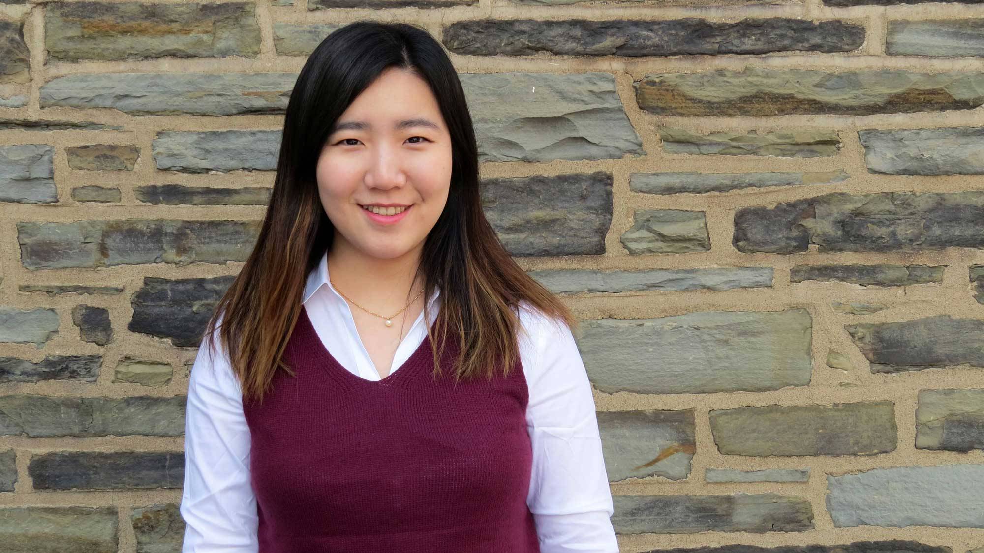 Watson Fellowship winner Minjoo Kim '20 in front of a stone wall