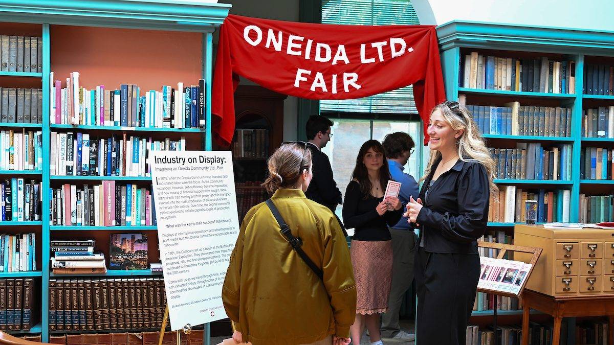 Elizabeth Armstrong ’25 speaks with guests about “Industry on Display,” an exhibit exploring the utopian community’s transition to silverware manufacturing during the opening of “Fresh Perspectives on the Oneida Community Mansion House” April 30. 