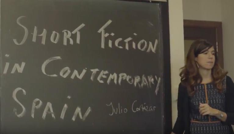 Marta Perez-Carbonell at a blackboard that reads Short Fiction in Contemporary Spain
