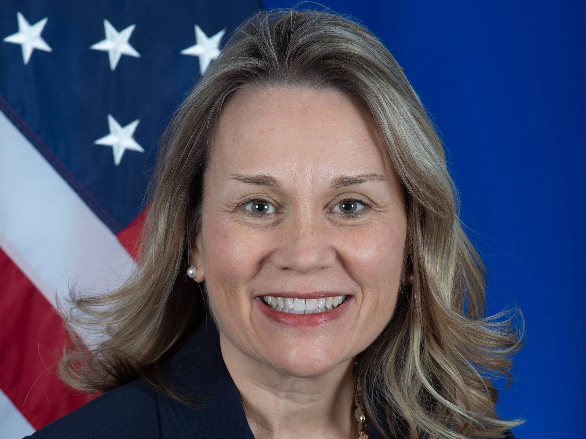 Head shot of Julianne Smith, American flag in the background