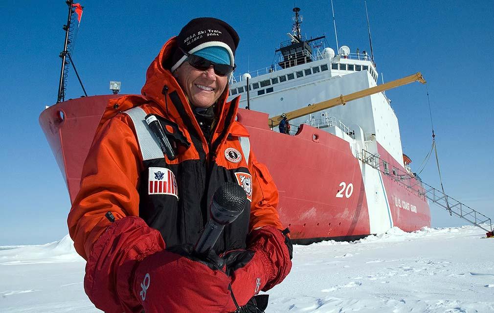 Elizabeth Arnold ’82 standing on ice in front of a ship