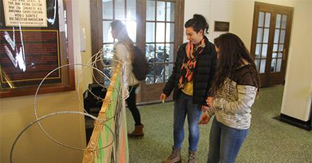 Two students examine a commemorative Berlin Wall in Lawrence Hall at Colgate University