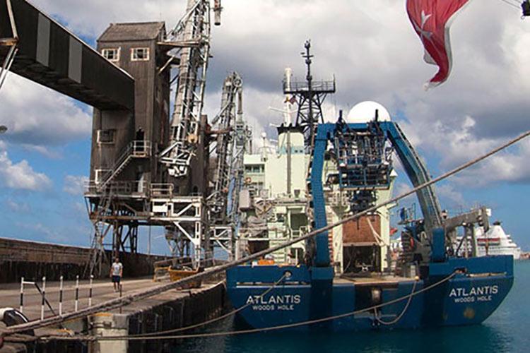 Research vessel Atlantis sits beside a dock.