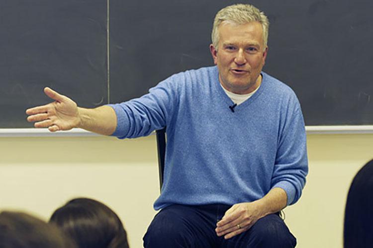 Duncan Niederauer ’81 with his hand extended while addressing students