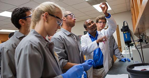 Engda Hagos, assistant professor of biology, works with students in his lab.