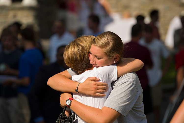 Mother and daughter hug at arrival day social