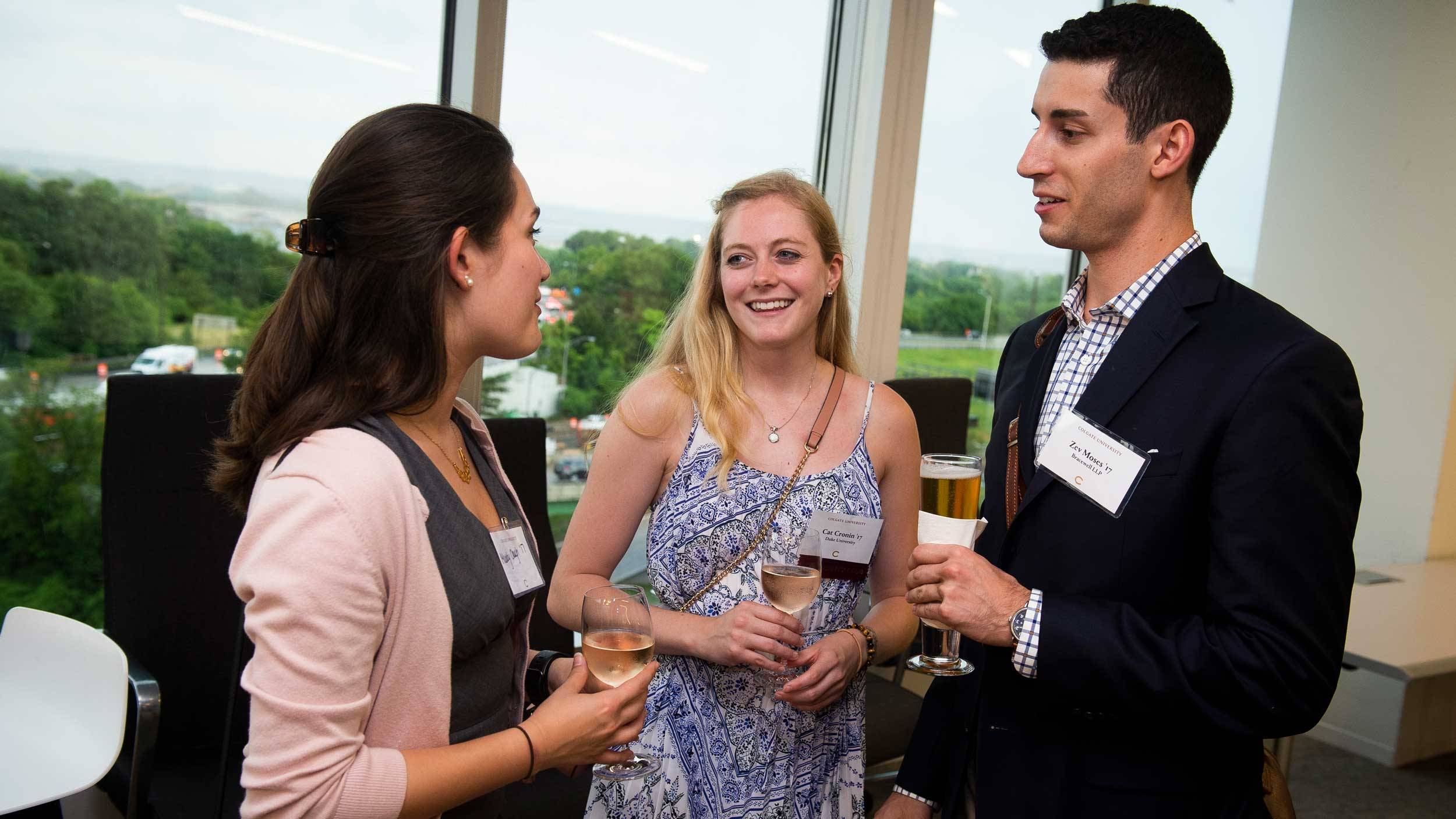 Three alumni engage in conversation