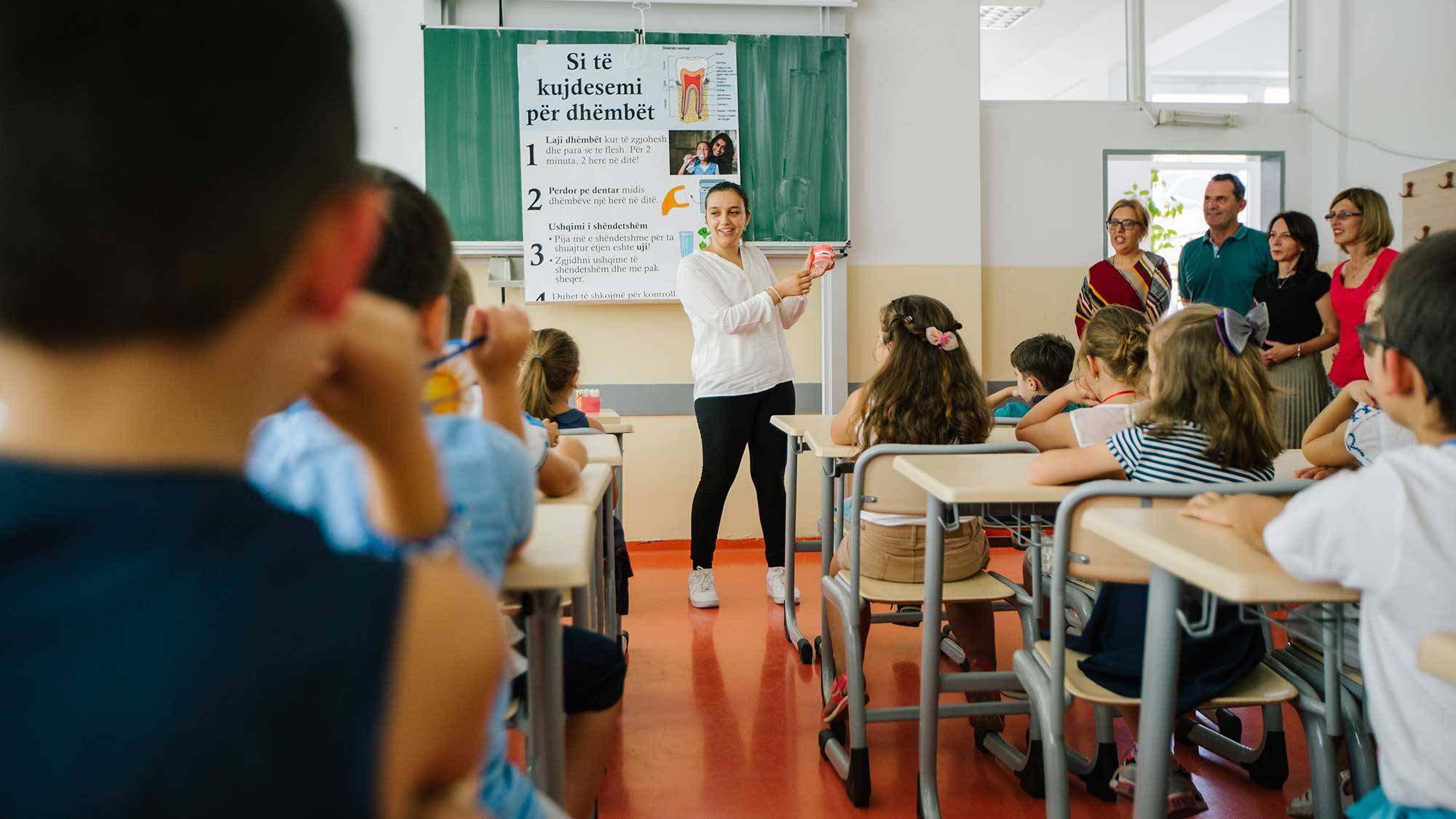 Oneida Shushe ’19 demonstrates proper brushing technique to classroom of students