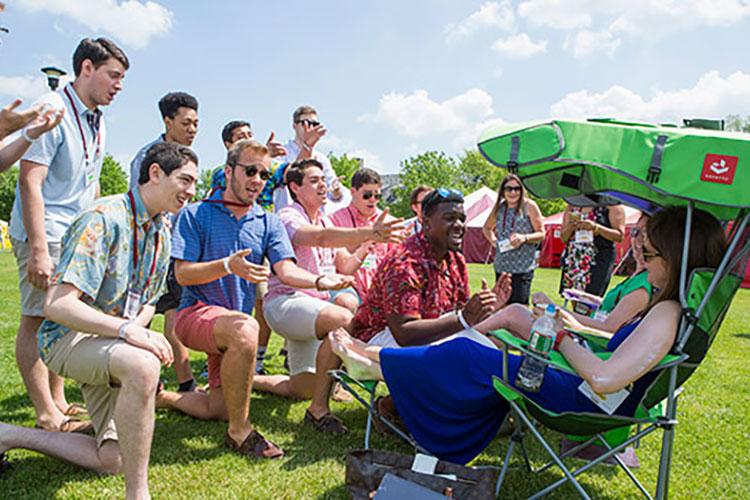 A cappella singers serenading two women seated in lawn chairs