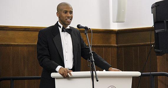 Sam Flood '14 speaking from a podium in the Hall of Presidents