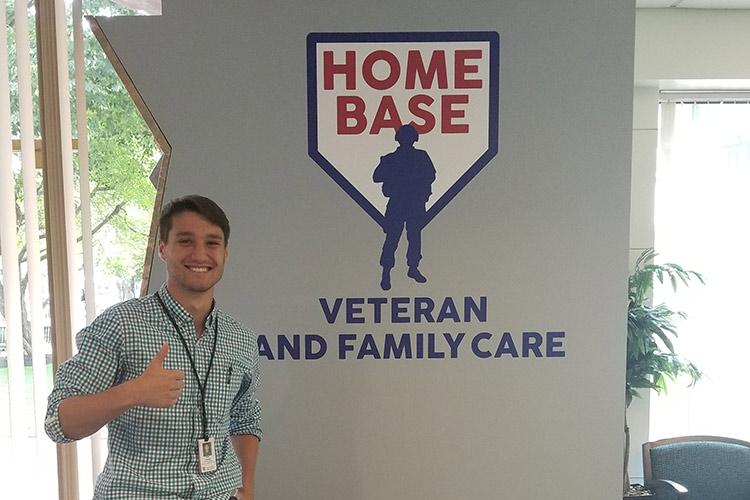 Peter Tappenden ’18 gives the thumbs up in front of the Home Base sign