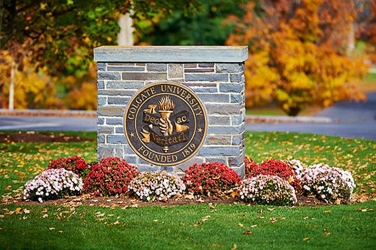 Flowers in front of the Colgate seal wall by James B. Colgate Hall