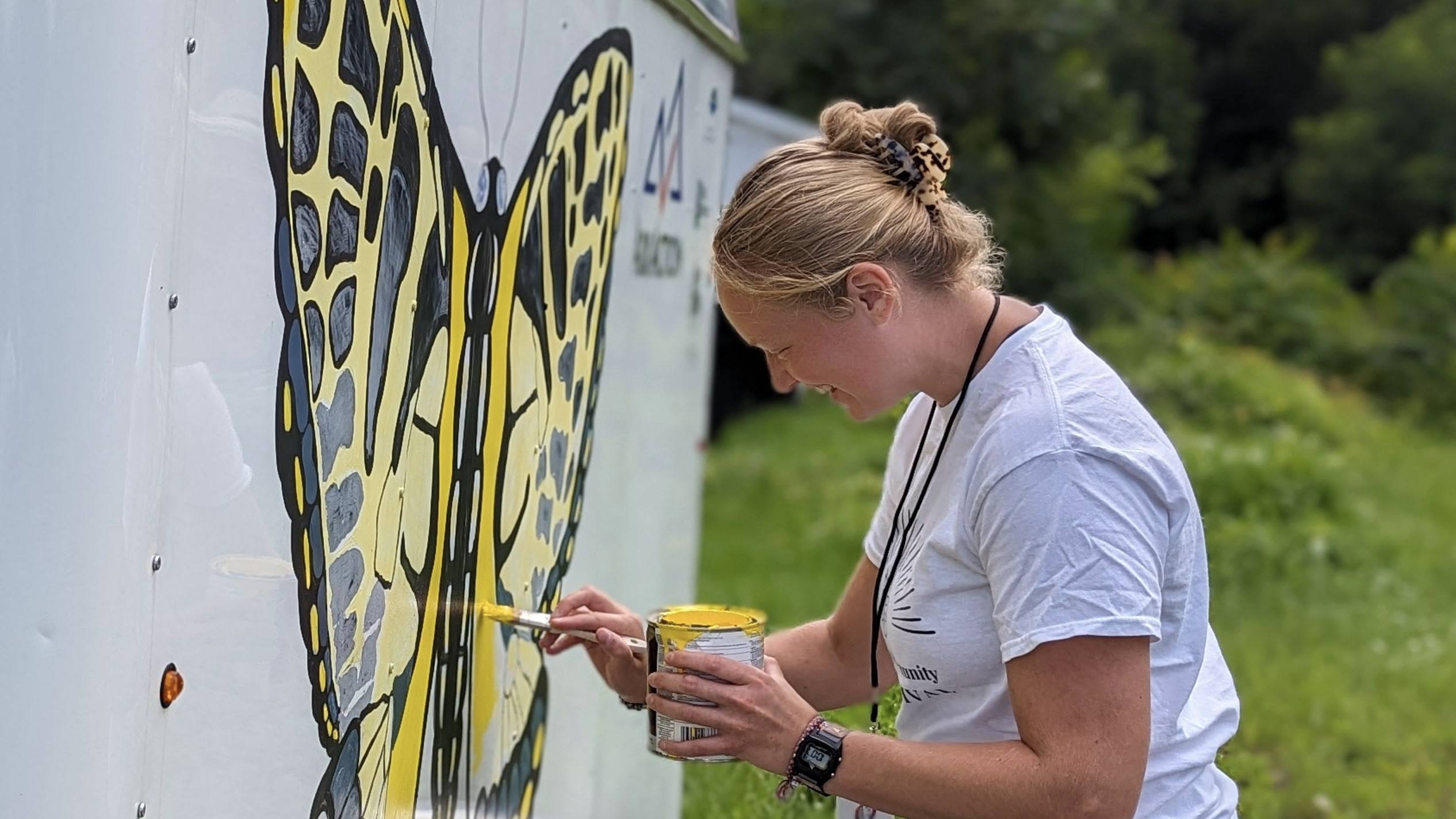 Kayla painting the AskAction “Pollinator-Mobile” 