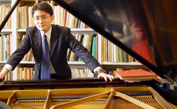 Assistant Professor of Music Zhou Tian stands by piano